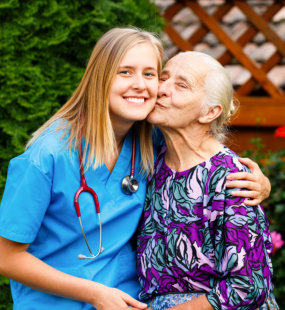 senior kissing caregiver on cheeks