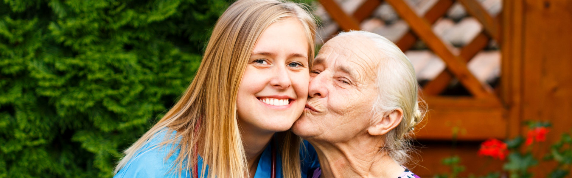 caregiver kissed by senior on cheeks